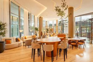 a lobby with tables and chairs in a building at Marriott Corrientes in Corrientes