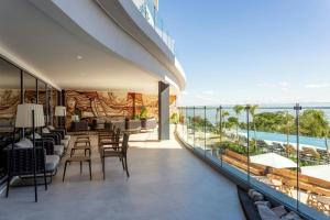 a balcony with tables and chairs and a view of the ocean at Marriott Corrientes in Corrientes