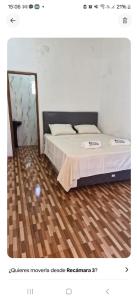 a bedroom with a bed and a wooden floor at Cabaña El Dorado, Alojamiento in Puerto Cantera