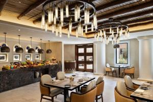 a dining room with tables and chairs and a chandelier at Bab Samhan, a Luxury Collection Hotel, Diriyah in Riyadh