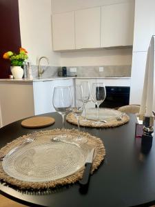 a table with two plates and wine glasses on it at Nuit Céleste Studio élégant avec parking Centre Morteau in Morteau