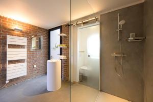 a bathroom with a shower with a glass door at Les Pieds au vert in Limbourg