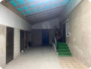 a hallway of a building with a blue door and green steps at Nurs Home in Dzhenish