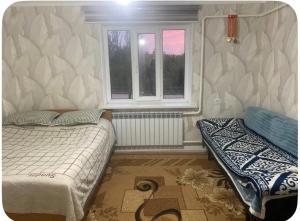 a bedroom with two beds and a window at Nurs Home in Dzhenish