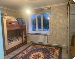a small room with a bed and a window at Nurs Home in Dzhenish