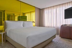 a bedroom with a large white bed and a television at W Sao Paulo in São Paulo +111 photos