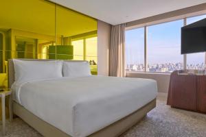a bedroom with a white bed and a large window at W Sao Paulo in São Paulo