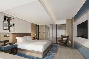 a hotel room with a bed and a tv at Four Points by Sheraton Rizhao Central Activities Zone in Rizhao +66 photos