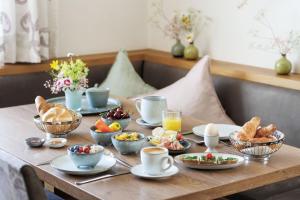 a table with cups and bowls of food on it at Landhaus Steiner in Altenmarkt im Pongau