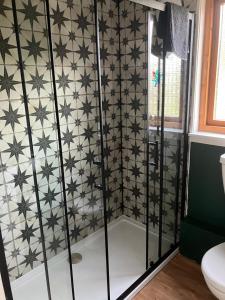 a bathroom with a black and white tiled wall at Vintage Retreat in Kingussie +4 photos