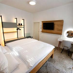 a bedroom with a large white bed and a desk at Villa Kirnach Private Spa Retreat im Allgäu in Biessenhofen