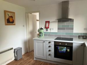 a kitchen with a stove and a counter top at Vintage Retreat in Kingussie