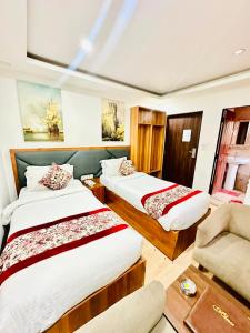 a hotel room with two beds and a chair at Hotel Attic Empire in Kathmandu