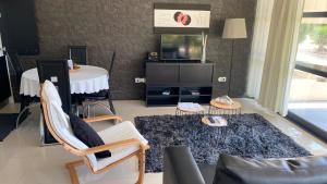 a living room with a couch and a tv at Cantinho das Buganvilias AT**** in Queimada
