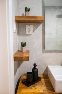 a bathroom with two plants on a shelf next to a sink at JM Apartment in Poprad +23 photos