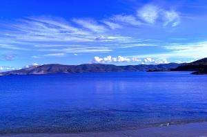 a large body of water with mountains in the background at 4 Seasons Island Suites Athens Airport in Markopoulo +37 photos