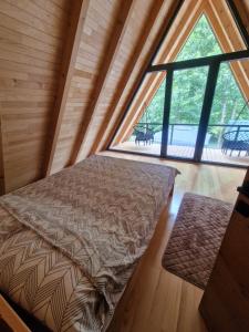 a bed in a room with a large window at River Zen House in Šipovo