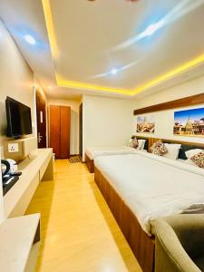a hotel room with two beds and a flat screen tv at Hotel Attic Empire in Kathmandu