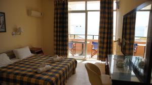 ein Hotelzimmer mit Bett und Balkon in der Unterkunft messonghi bay in Mesongi