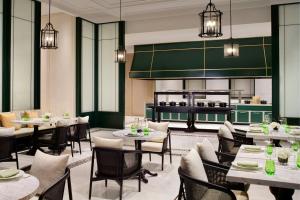 a restaurant with tables and chairs and a kitchen at The Ritz-Carlton, Suzhou in Suzhou