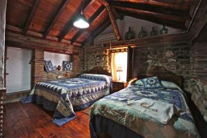 a bedroom with two beds in a log cabin at Alojamientos Rurales Colonos in Guarromán