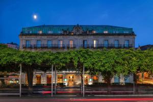 ein großes Gebäude mit Bäumen davor in der Unterkunft AC Hotel Palacio Universal by Marriott in Vigo