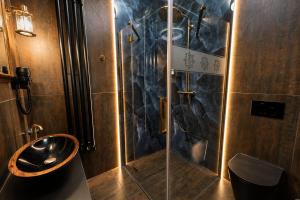 a bathroom with a glass shower and a sink at Boutique rooms Fabrika in Děčín +55 photos