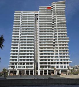 a tall white building with a red circle on it at Triple Tower 23eme étage La vue 329 gare tgv & plage 3min in Tangier