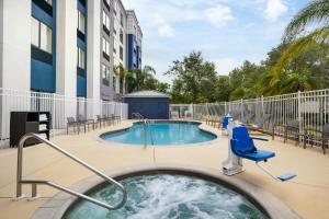 a hot tub with a chair next to a swimming pool at SpringHill Suites by Marriott - Tampa Brandon in Tampa