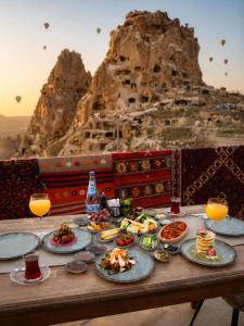 a table with plates of food and glasses of orange juice at Duven Hotel Cappadocia in Uçhisar