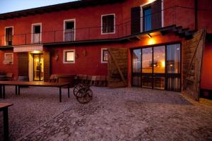 un edificio rojo con una mesa delante en Agriturismo Frascje Dai Spadons, en Pradamano