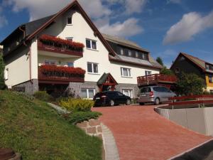 a large white house with red flowers on the balconies at Ferienwohnungen Haseloff in Kurort Oberwiesenthal
