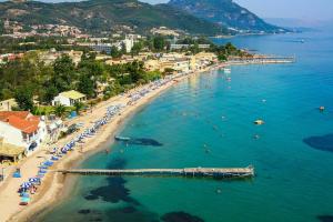 ein Strand mit Sonnenschirmen und Menschen im Wasser in der Unterkunft messonghi bay in Mesongi + 16 Fotos