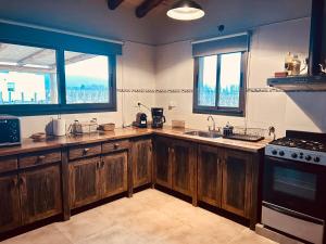 a kitchen with wooden cabinets and a sink and two windows at Finca Rosablanca Casa Jazmin in Vista Flores