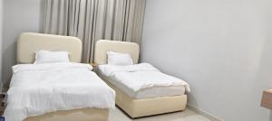 a room with two beds and a chair at فلل فاخرة للإيجار صلالة Salalah Villas in Salalah