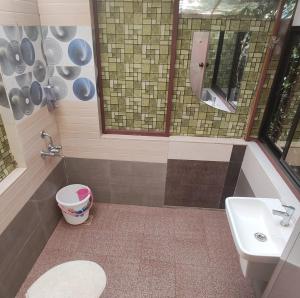 a bathroom with a sink and a toilet and a mirror at WeK Homes in Kumbla