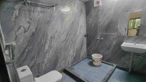 a bathroom with a toilet and a sink at WeK Homes in Kumbla