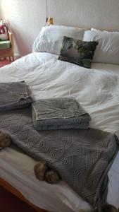 a white bed with a pile of blankets on it at Vintage Retreat in Kingussie