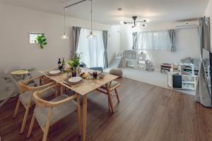 a dining room with a table and chairs and a bedroom at Sion MINATO in Nagoya