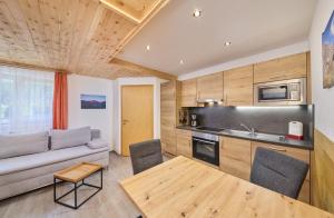 a kitchen and living room with a couch and a table at Appartement Lea in Niederthai