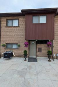 a red brick building with a door and flowers at North York Quiet Room#2 in Toronto