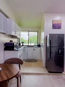 a kitchen with a stainless steel refrigerator and white cabinets at Central Luxury Apartments in Georgetown