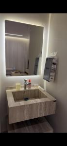 a bathroom with a stone sink and a mirror at Elite stay 1 in Buraydah