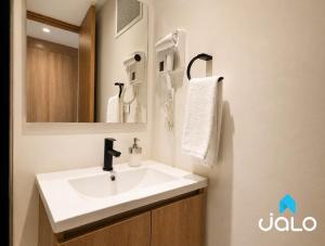 a bathroom with a white sink and a mirror at Well 100 by JALO in Bogotá