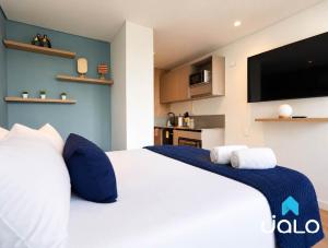 a bedroom with a white bed and a flat screen tv at Well 100 by JALO in Bogotá +52 photos