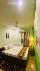 a bed in a room with a green wall at The Third Space Varanasi in Rāmnagar