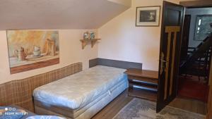 a small room with a bed and a desk at Chata Johanka in Stachy