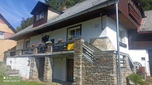 a house with a balcony with people on it at Chata Johanka in Stachy