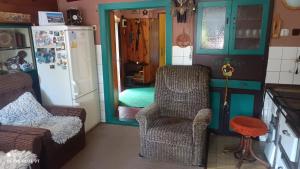 a living room with a chair and a refrigerator at Chata Johanka in Stachy