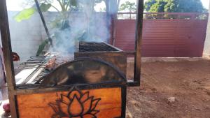 a grill with smoke coming out of it at Muzinge inn in Kagolomolo